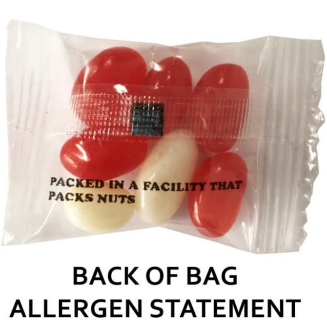A plastic bag containing red and white jelly beans, with a printed allergen statement on the back.