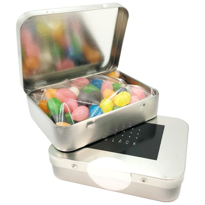 A silver rectangular tin filled with colourful jelly beans, partially open to reveal the vibrant sweets inside.