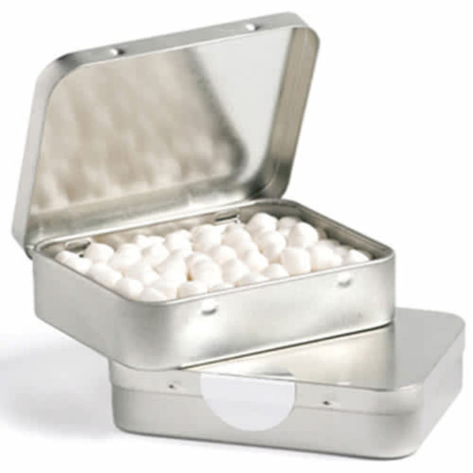 A rectangular silver tin with a hinged lid, filled with small white mints, and featuring a logo on the surface.