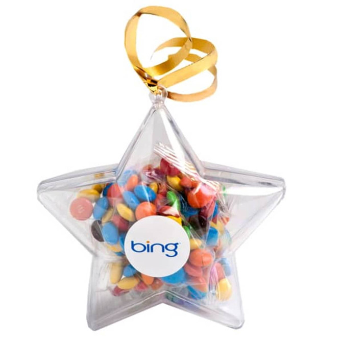 A clear acrylic star filled with colourful M&Ms, featuring a ribbon for hanging and a branded sticker.