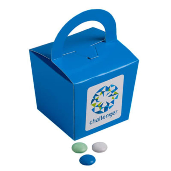 A blue noodle box featuring a handle, accompanied by three colourful choc beans in green and blue.