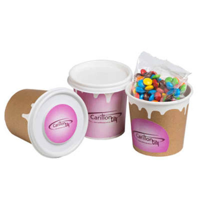A coffee cup with a lid, featuring a decorative design, filled with colourful M&Ms in a clear bag.
