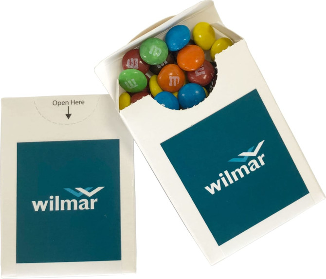 A branded flip lid cardboard box in white, containing colourful chocolate-coated M&Ms.