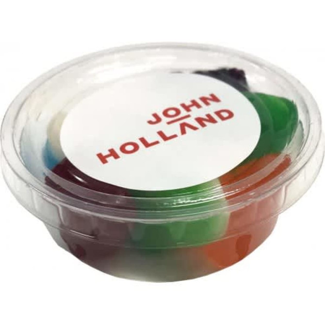 A transparent tub filled with mixed lollies in various colours, featuring a branded label on top.