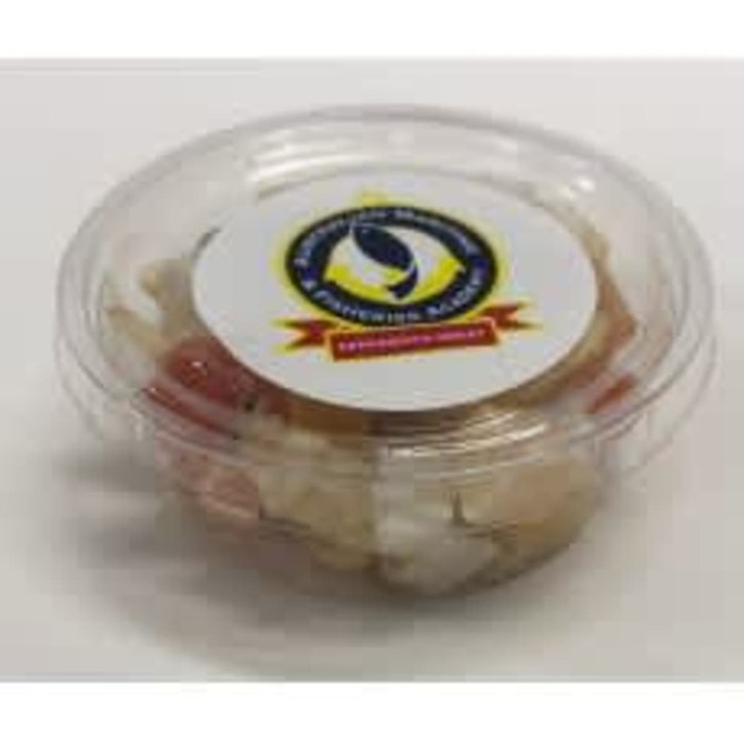 A clear tub containing a mixed dried fruit assortment, featuring various colours like red, white, and yellow.