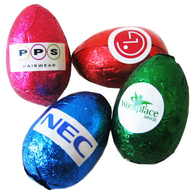 Four hollow chocolate eggs in pink, red, green, and blue foil, featuring various logos.