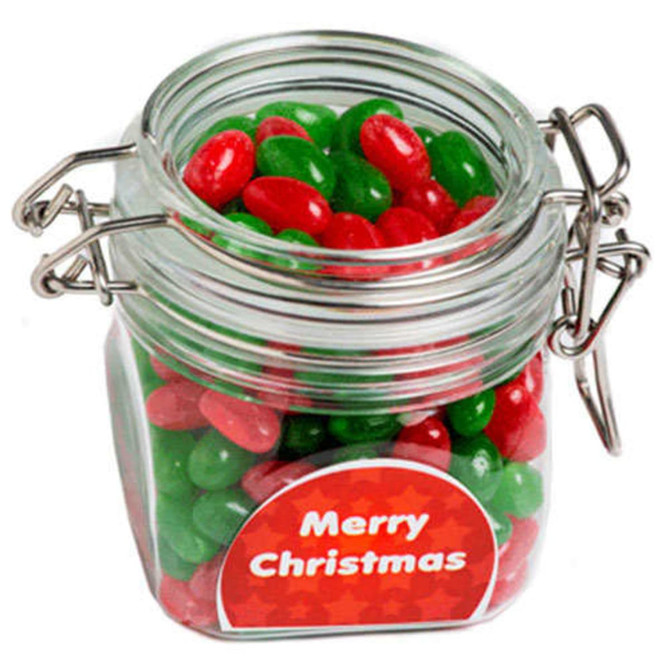 A clear glass canister filled with red and green jelly beans, sealed with a metal clasp.