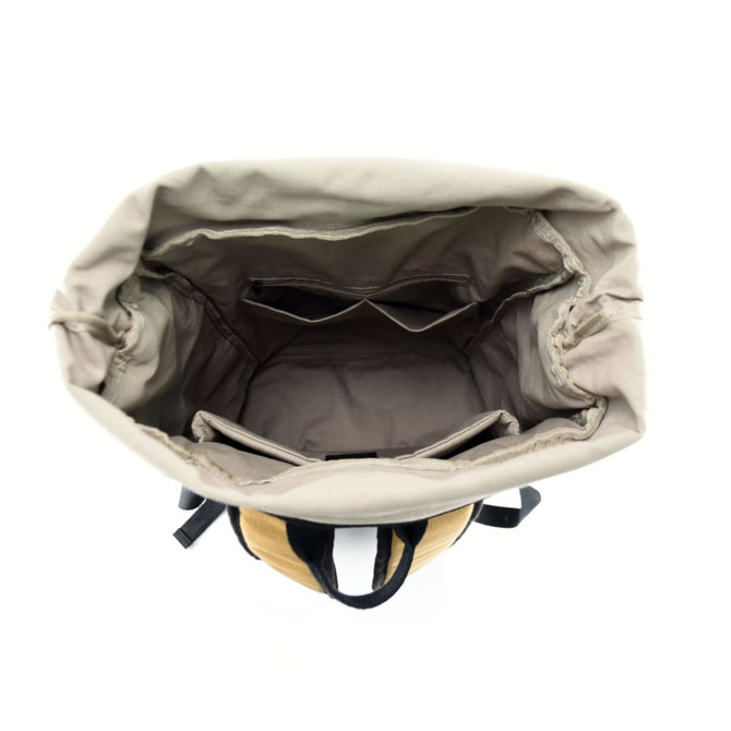 An overhead view of a tan and brown kraft paper laptop backpack, featuring a spacious interior with dividers.