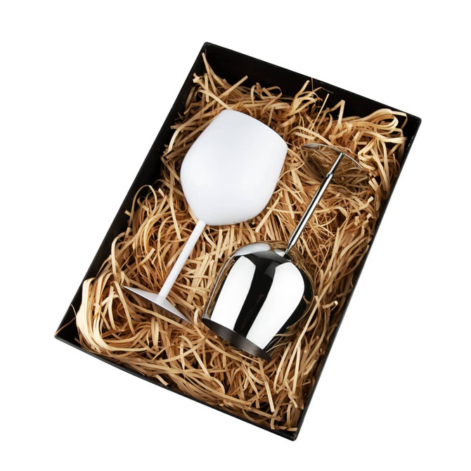 A stainless steel wine glass and a white wine glass displayed in a black box with straw filler. The box has a logo.