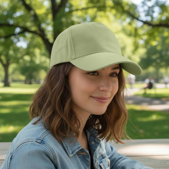 A drink bottle in light green with a curved peak, featuring a logo on the front. Surrounded by greenery.