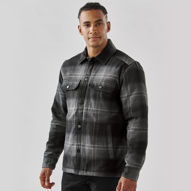 A men's black and grey plaid jacket with a Sherpa lining and button front, featuring two chest pockets and a logo.