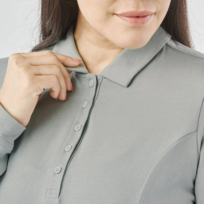 A close-up of a woman adjusting the collar of a grey long-sleeve polo shirt with buttons and a logo.