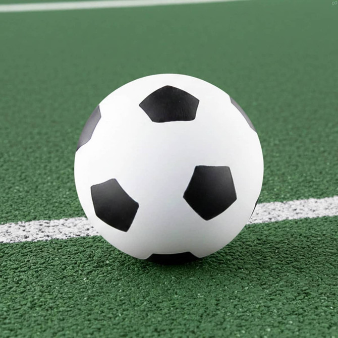 A high bounce soccer ball featuring a classic black and white design, resting on a green surface.
