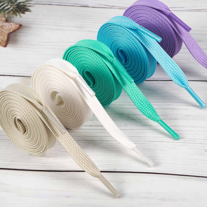 Double-layer shoelaces displayed in beige, light green, dark green, blue, and purple on a wooden surface.