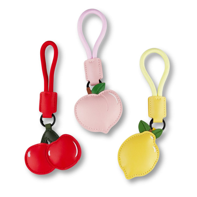 Three bag charms in red, pink, and yellow shaped like cherries, a peach, and a lemon, with loops for attachment.