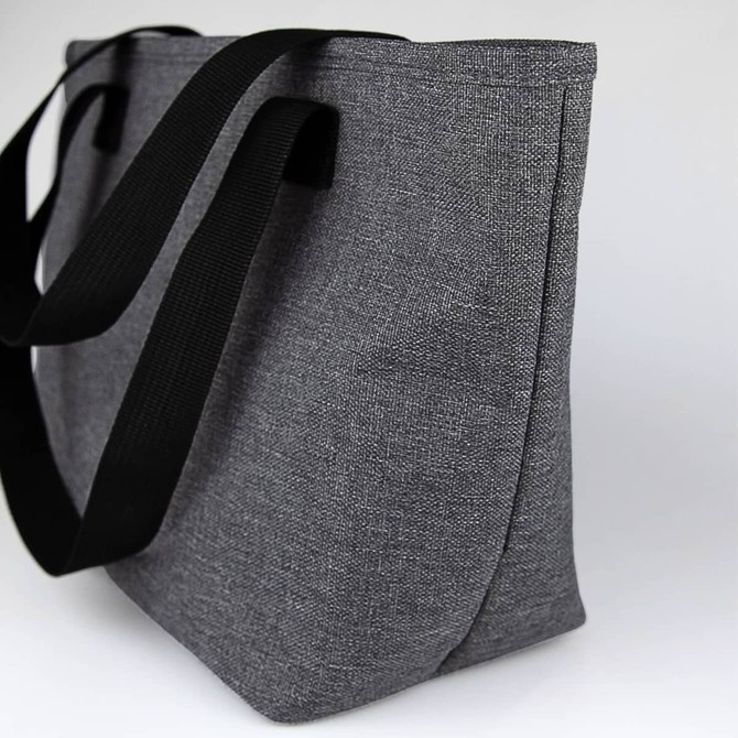A grey lunch bag with black straps, featuring a simple design and an external logo.