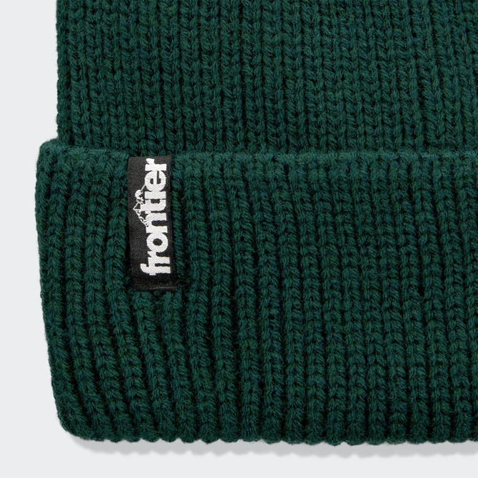 A dark green beanie with a knitted texture and a small black logo label.