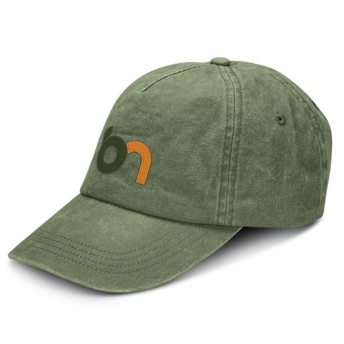 A vintage washed cap in olive green with a logo on the front. The cap features a curved brim and textured fabric.
