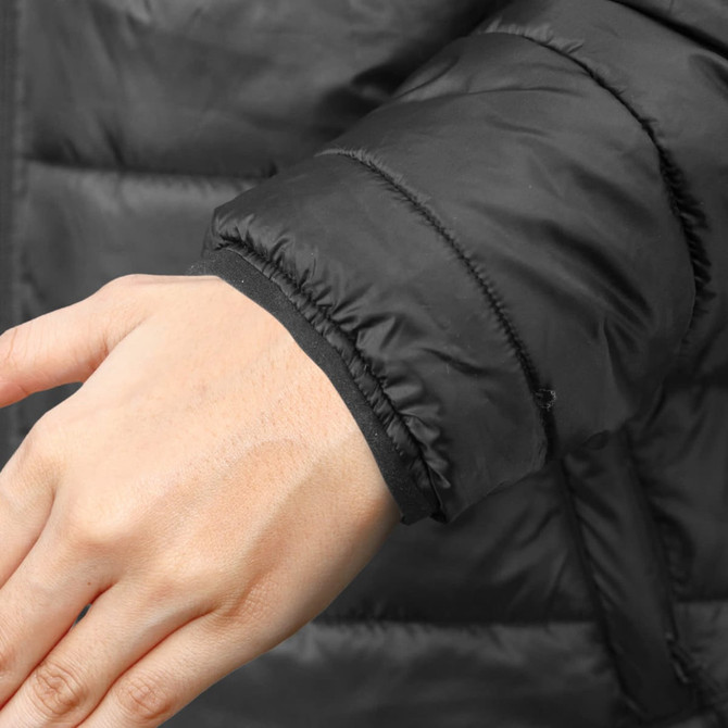 A close-up of a hand wearing the cuff of a black puffer jacket, featuring a snug fit around the wrist.