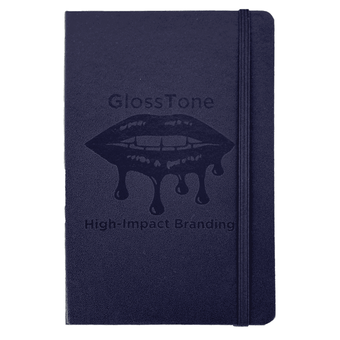 A navy blue journal with a textured cover and an elastic closure. It features a branding logo on the front.