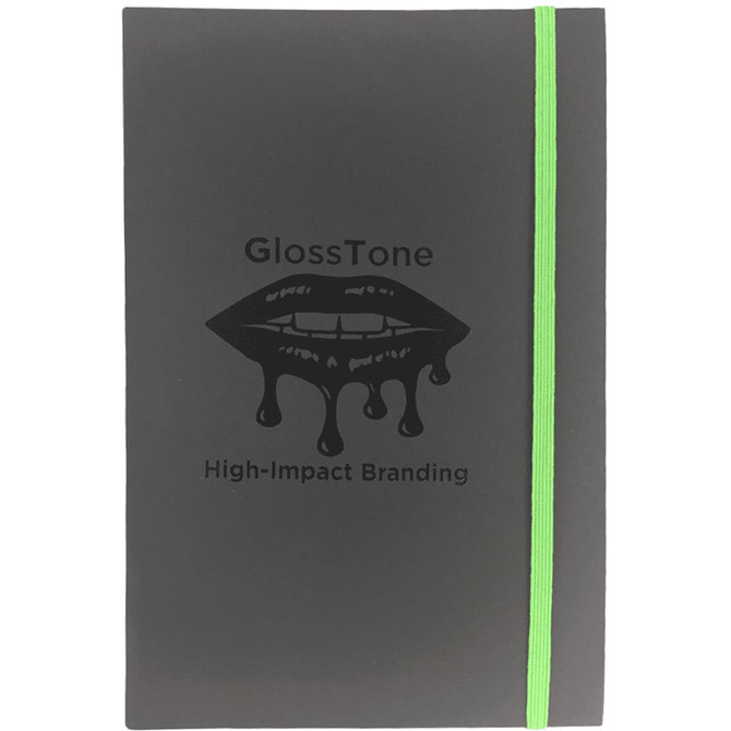 A black journal with a green elastic band, featuring a lip graphic and branding on the cover.