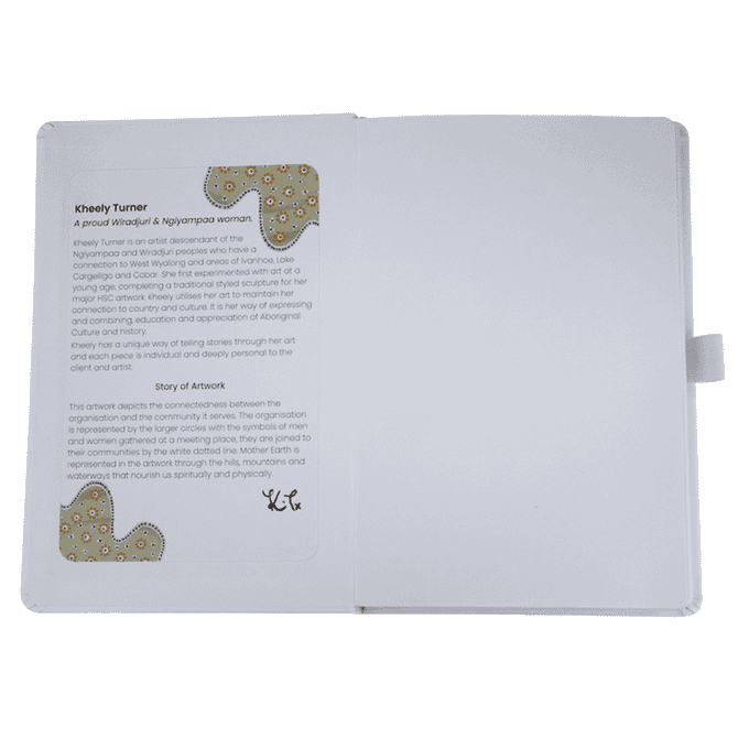 An open journal book featuring a textured white cover, showcasing a page with an artistic design and text.