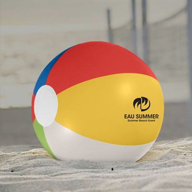 A beach ball with red, yellow, blue, and green panels, featuring a logo, resting on sandy ground.