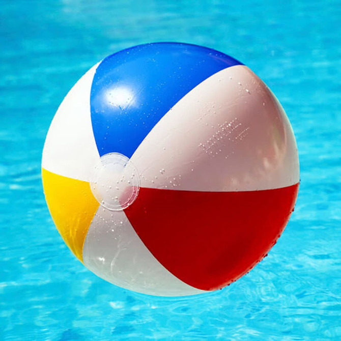 A vibrant beach ball featuring blue, red, yellow, and white panels, floating in a pool of water.