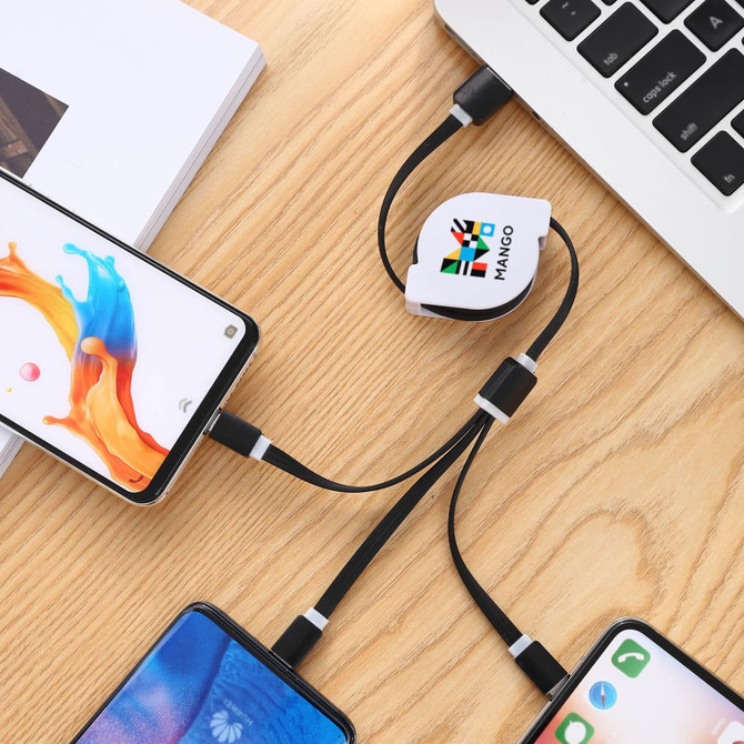 A retractable charging cable in black and white, connecting multiple smartphones to a laptop on a wooden surface.