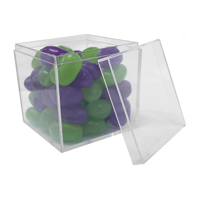 A clear cube container filled with green and purple jelly beans, partially open.