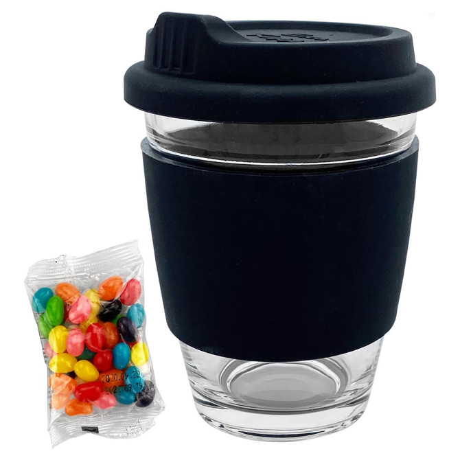 A clear glass coffee cup with a black silicone sleeve and lid, alongside a pack of colourful jelly beans.