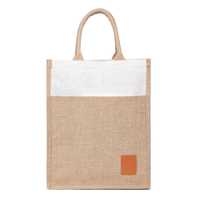 A reusable jute bag in natural brown with a white top and a brown leather patch, featuring two handles.