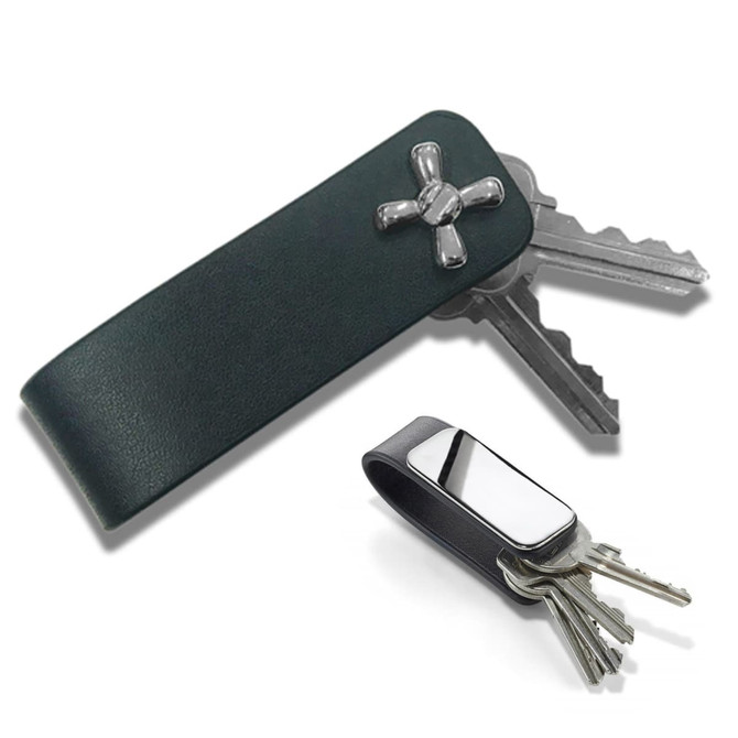 A green leather key holder with a metallic accent, holding multiple keys alongside a silver key holder.
