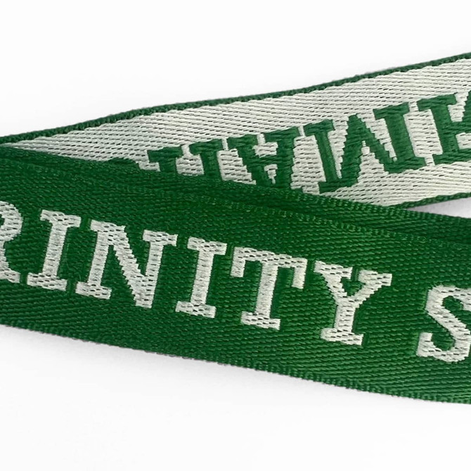 A green woven lanyard with white text, featuring a logo or branding on its surface.