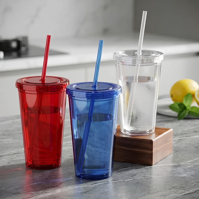 A drink tumbler set featuring red, blue, and clear plastic cups with straws, placed on a marble countertop.