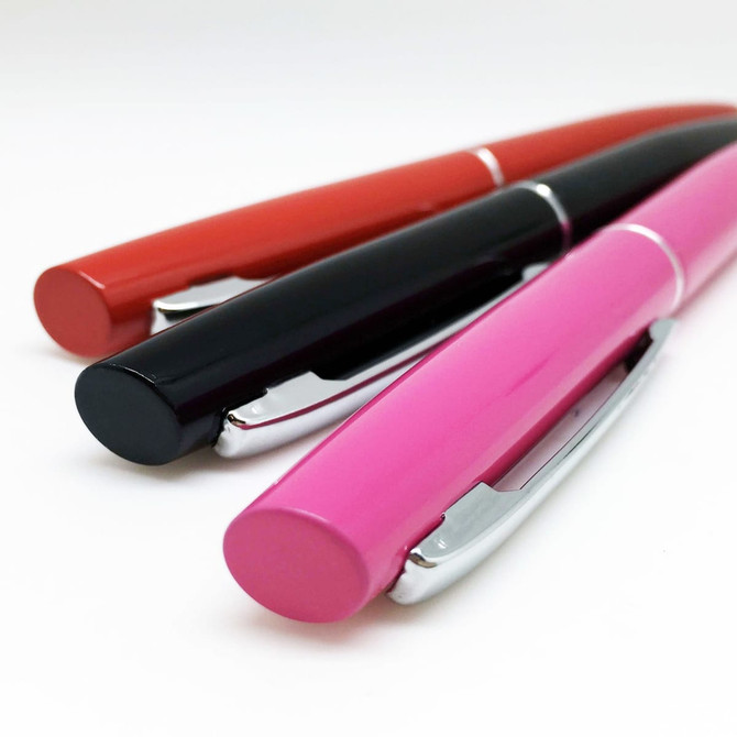 Three metal pens in red, black, and pink, featuring a silver clip and a glossy finish.