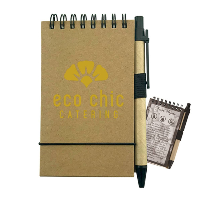A brown stone paper notebook with a spiral binding, accompanied by a black pen and featuring a small notepad.