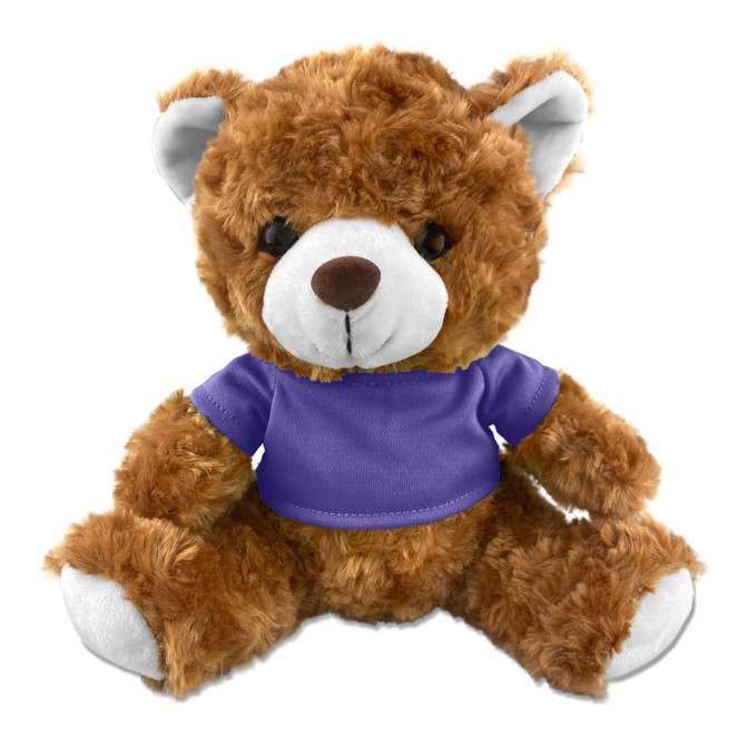 A brown teddy bear plush toy wearing a purple shirt, with soft fur and a friendly expression. It has a logo on the shirt.