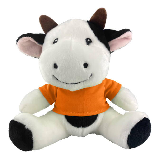 A plush cow toy with black and white fur, wearing an orange shirt, featuring a friendly smile and brown horns.