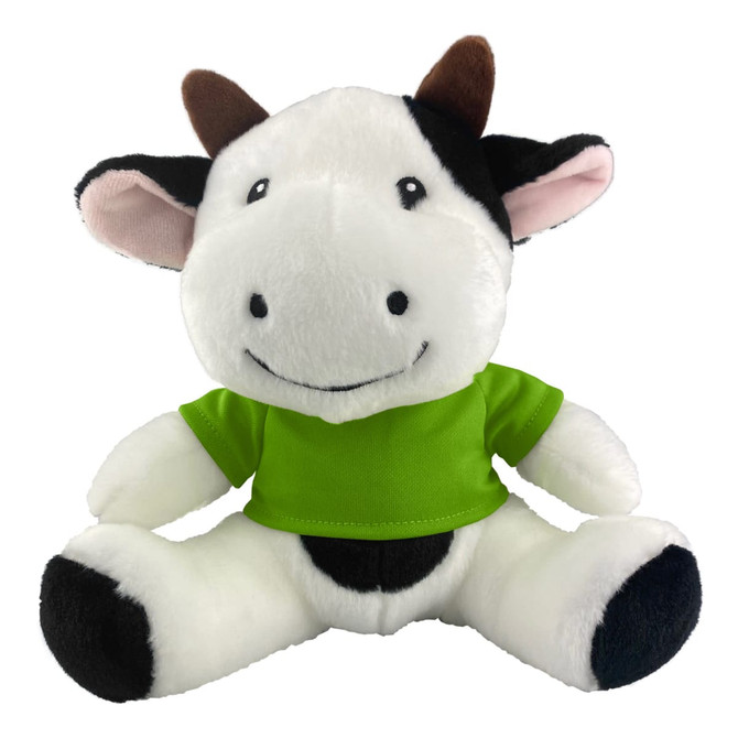 A plush cow toy with black and white fur, wearing a bright green shirt, sitting with a cheerful expression.