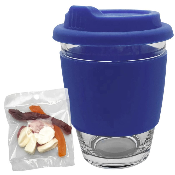 A reusable glass coffee cup with a blue silicone lid and sleeve, accompanied by a pack of jelly candy.