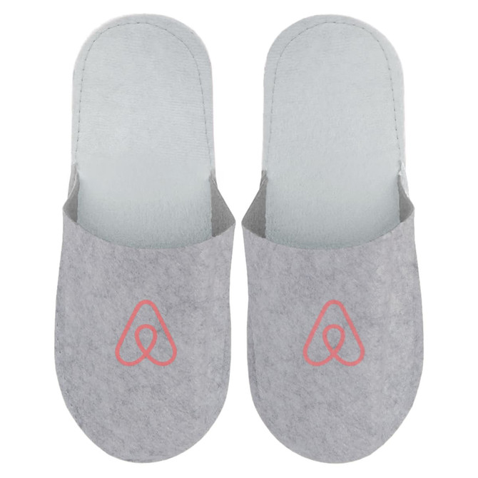 Grey felt slippers featuring a logo on the front, designed for comfort and cosy wear.