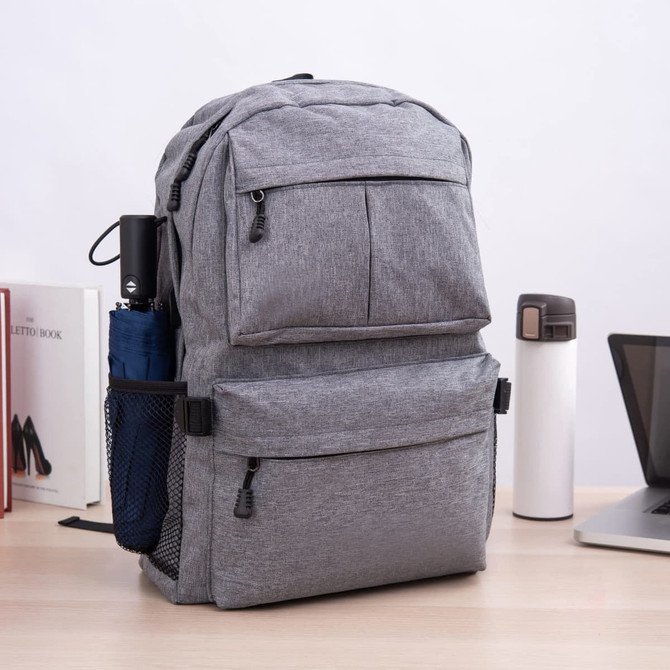 A grey laptop backpack with multiple compartments, side mesh pockets, and a classic design on a desk.