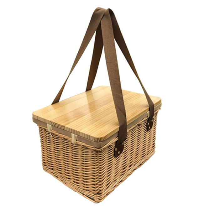 A square wicker picnic cooler basket in natural hues with a wooden lid and brown straps. Features a logo.