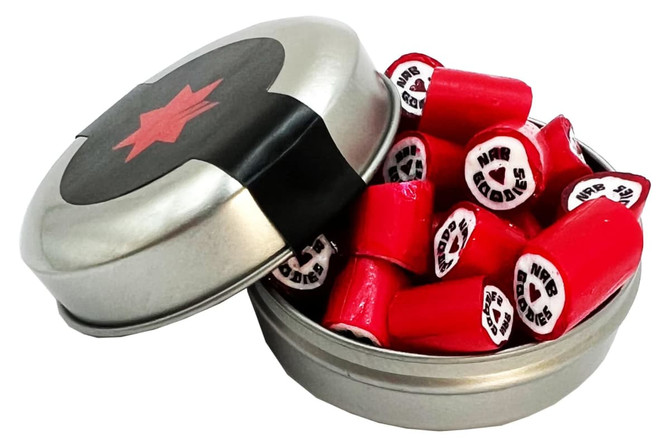 A silver tin filled with red rock candy pieces, some displaying black and white designs, with a black lid featuring a red star.