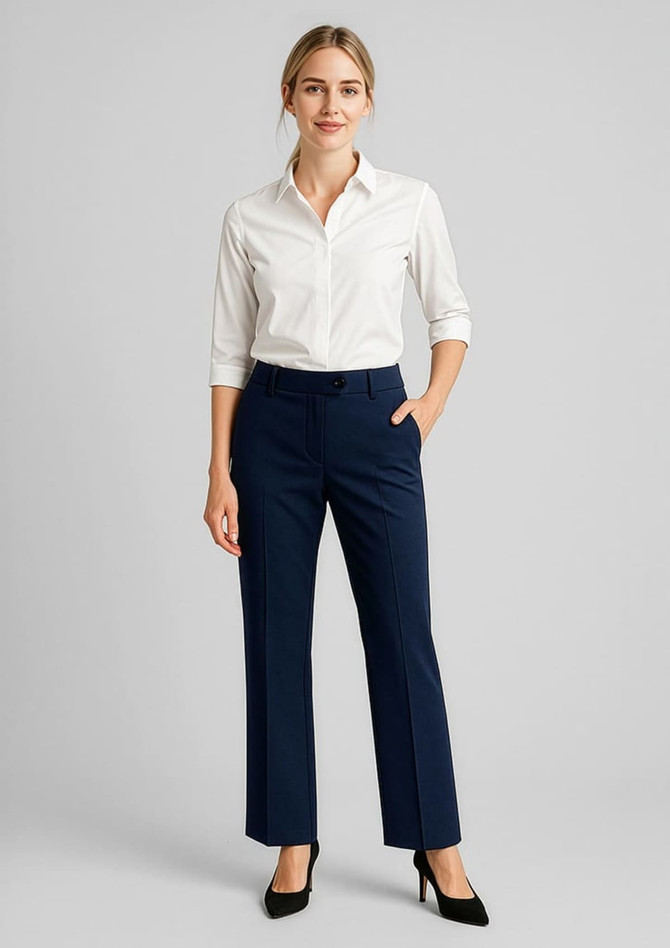 A woman poses in navy adjustable waist pants paired with a white shirt and heels, featuring a logo on the waistband.