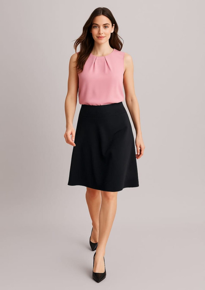 A woman is wearing a pink blouse with a black flared skirt, standing in a neutral background. The skirt has a smooth finish and a logo.