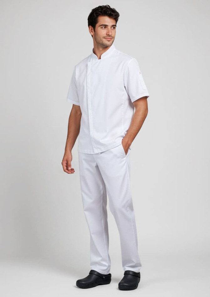 A white short sleeve chef jacket worn by a man, paired with white trousers and black shoes, featuring a logo.