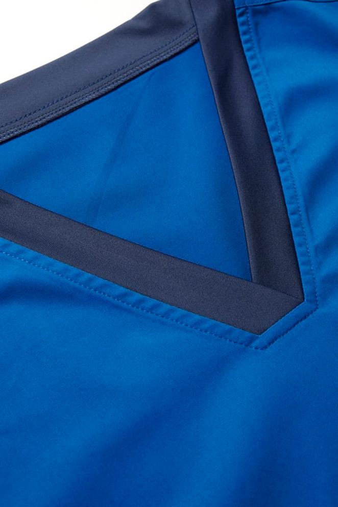 A close-up of a blue scrub top featuring a V-neckline with a contrasting dark blue trim.