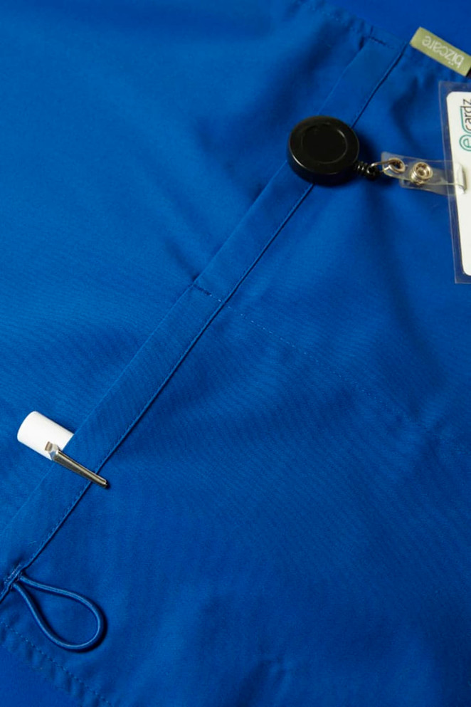 A blue men's scrub top featuring a badge holder and a security reel. The fabric has a smooth texture.